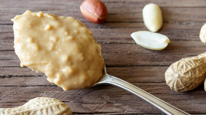 Woman reading the label on a jar of peanut butter at the grocery store