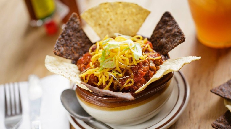 Bowl of chili with cheese and tortilla pieces