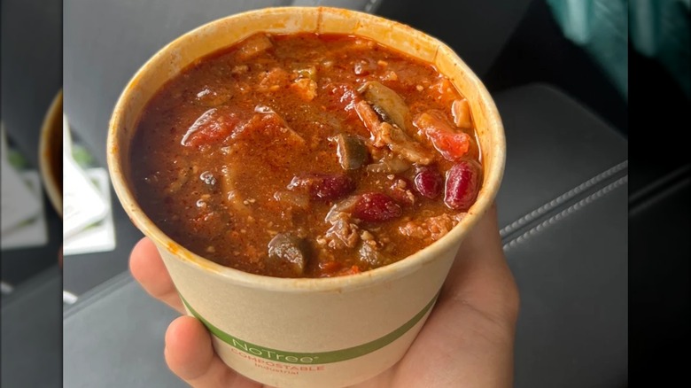 Hand holding a cup of chili