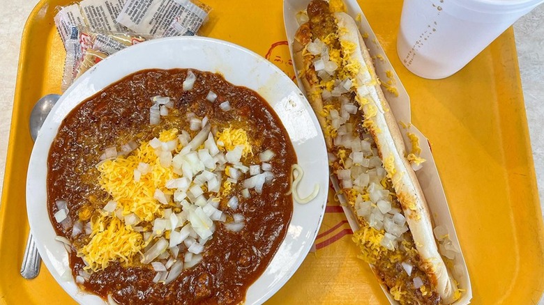 Bowl of chili, chili dog, and drink on yellow tray