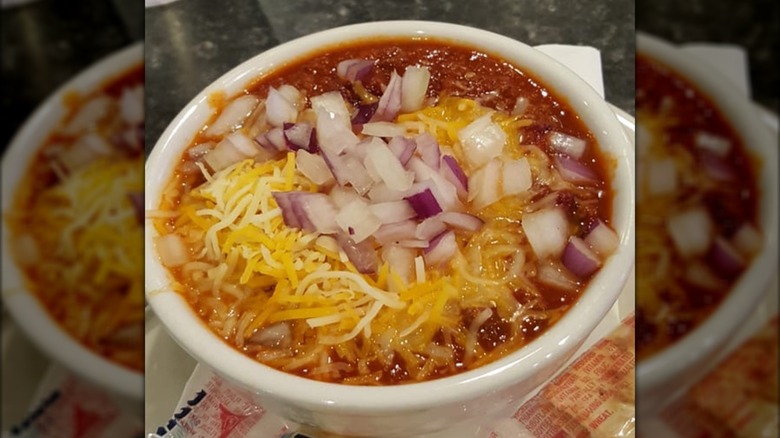 Bowl of chili with onions and cheese