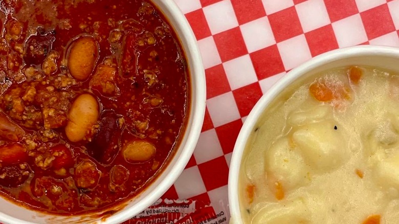 Bowl of chili with beans and bowl of soup on red and white checkered background