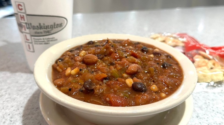 Bowl of chili with Camp Washington branded drink in background