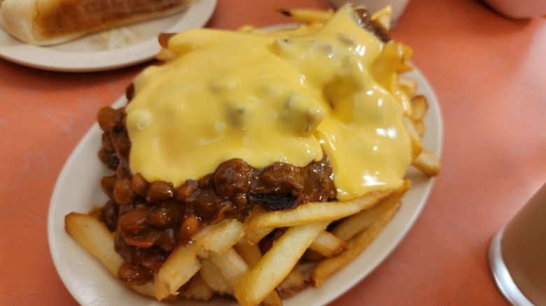 Chili cheese fries on orange-red table
