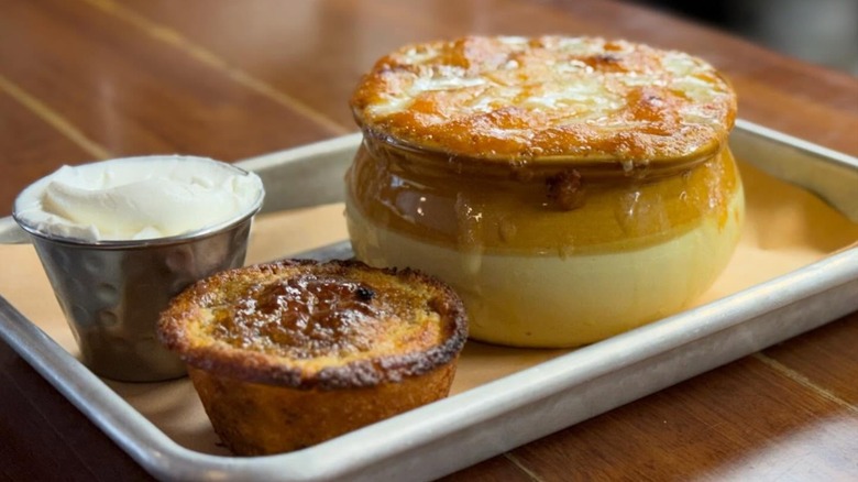 Crock of chili and cheese with sour cream and muffin