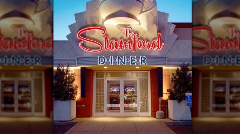 Exterior of Stamford Diner with a neon sign and large teacup sculpture