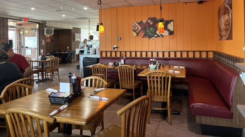 Seating area inside Odessa Diner with a corner booth and photos of food on the walls