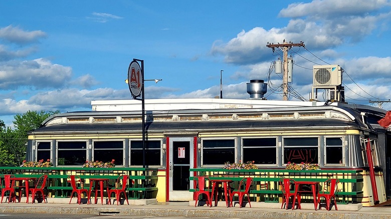 Exterior of A1 Diner with green railings and red tables outside on a sunny day