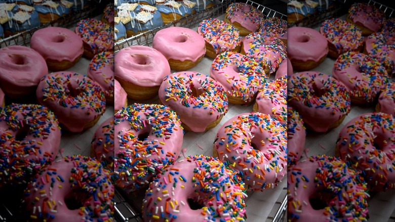 Pink-frosted raised donuts on a tray