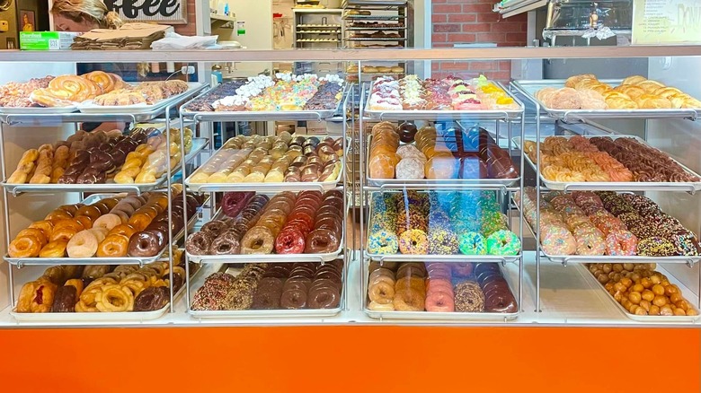 Display case full of donuts and pastries at Glaze Donuts
