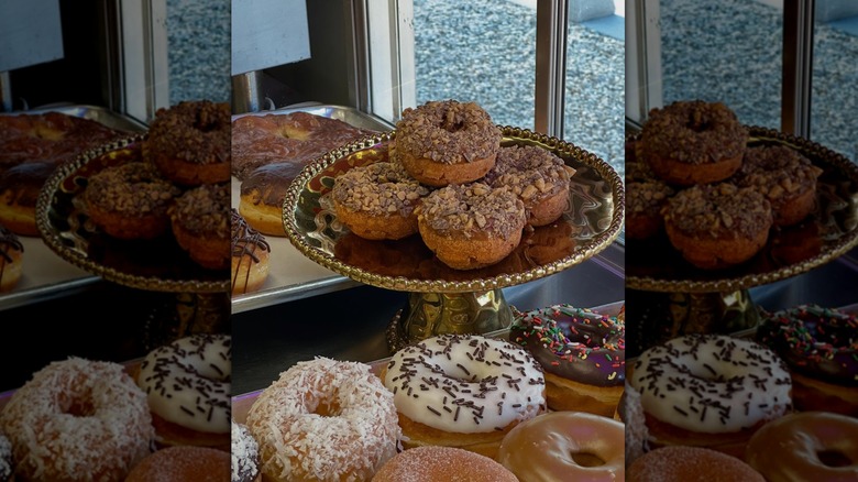 A variety of donuts on display in the window of Manna's Donuts