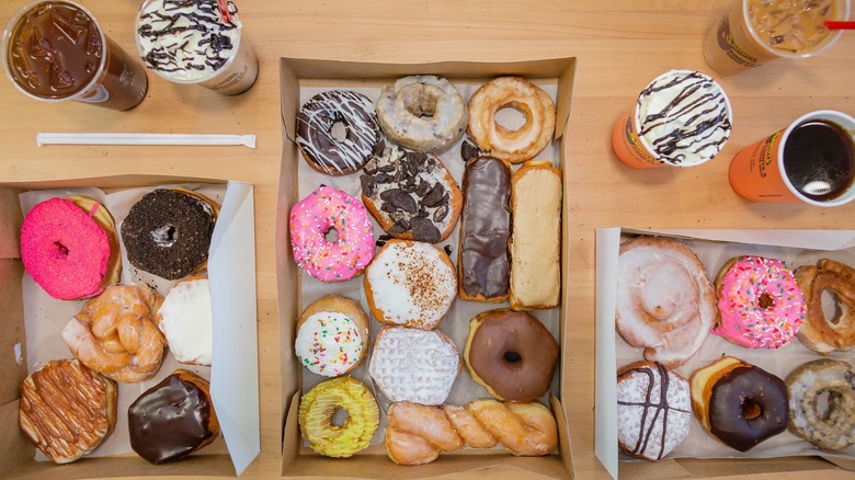 Display of boxes of various donuts and cups of coffee from Sandy's Donuts and Coffee Shop