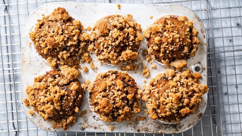 top-down view of six pumpkin muffins, made with prunes, on a cooling rack
