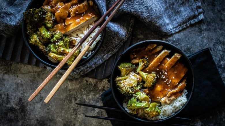 A top-down view of two bowls of sheet pan chicken teriyaki, made with prune puree