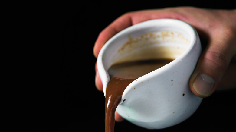 hand Pouring sauce from a cup