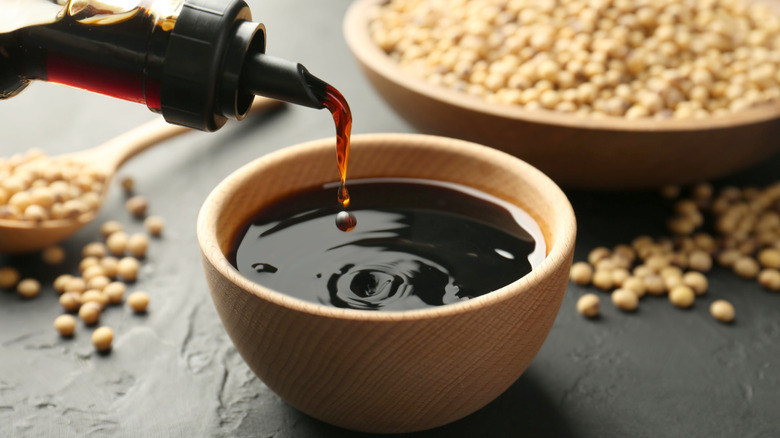 Pouring soy sauce into a bowl.