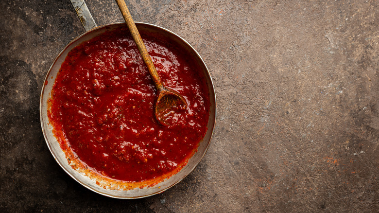 A classic homemade pasta sauce in a pan with a wooden spoon