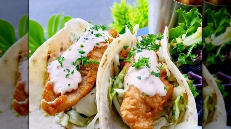 Two fried fish tacos with greens
