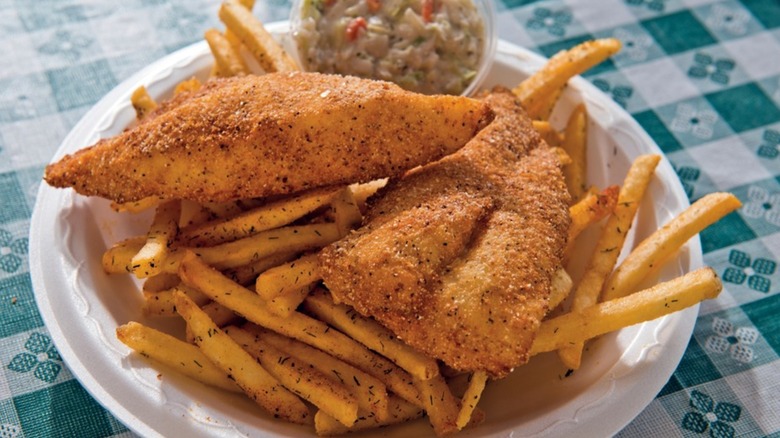 Fried fish filets with fries and coleslaw on plate