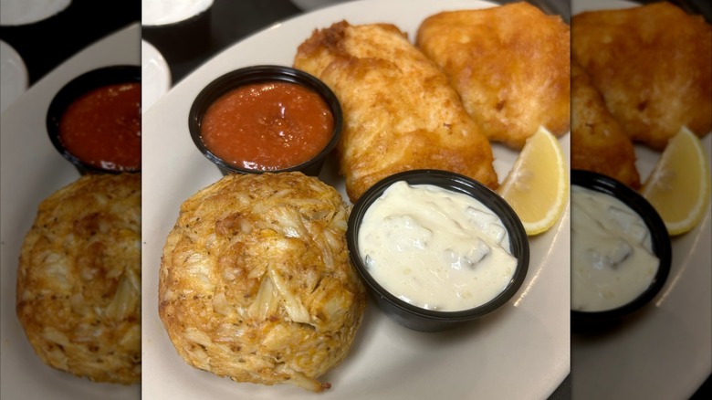 Platter with crab cake, dips, two pieces of fried fish, and lemon