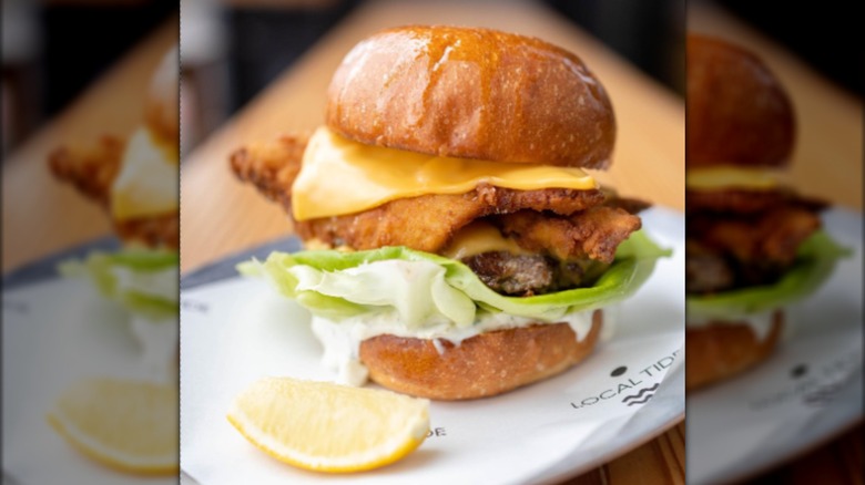 Burger with lemon wedge on plate
