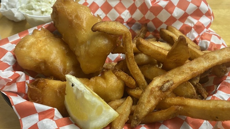Fish and chips with lemon on red-and-white checkered paper