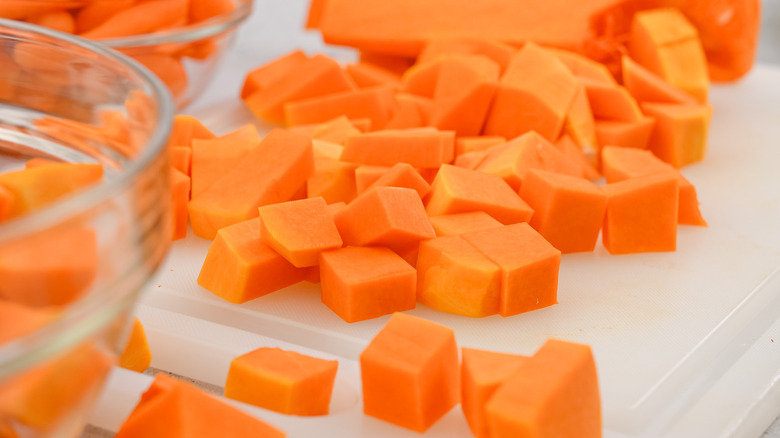 cubed butternut squash on a white cutting board