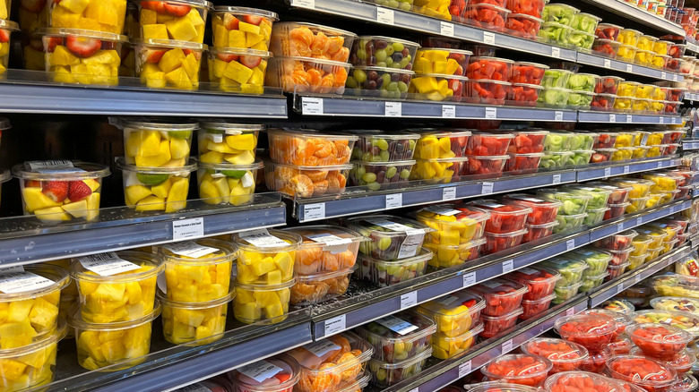grocery store shelf of assorted cut fruit in plastic containers