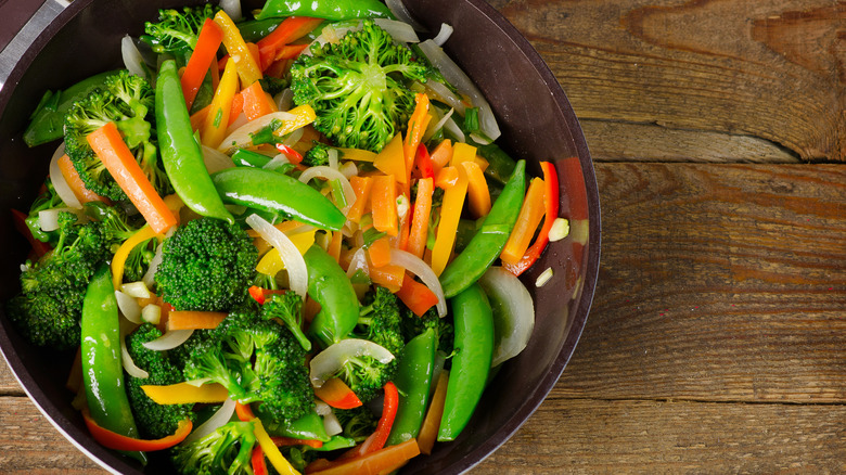 a bowl of classic stir-fry veggies like broccoli, snap peas, bell peppers, carrots, and onions