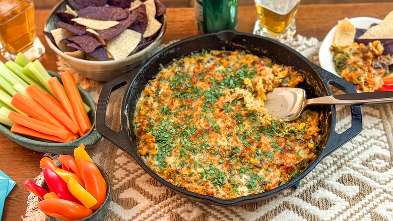 The best game day cheesy crab dip in cast iron skillet with dippers