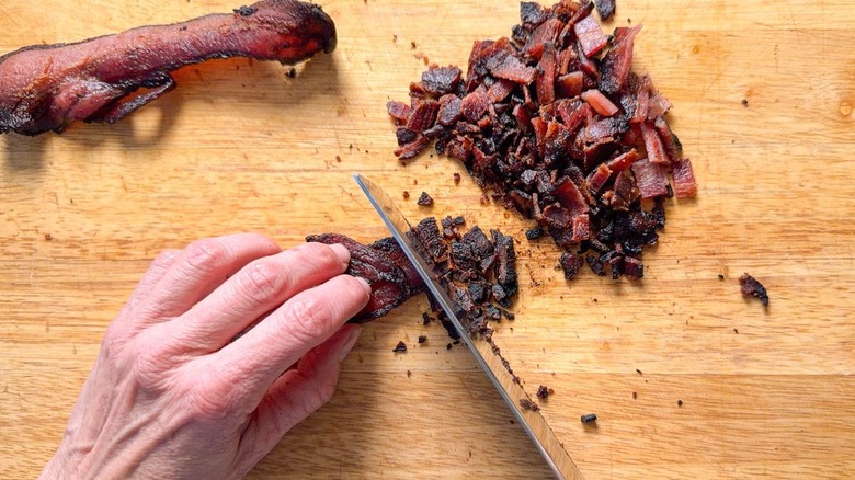 Chopping cooked bacon on cutting board