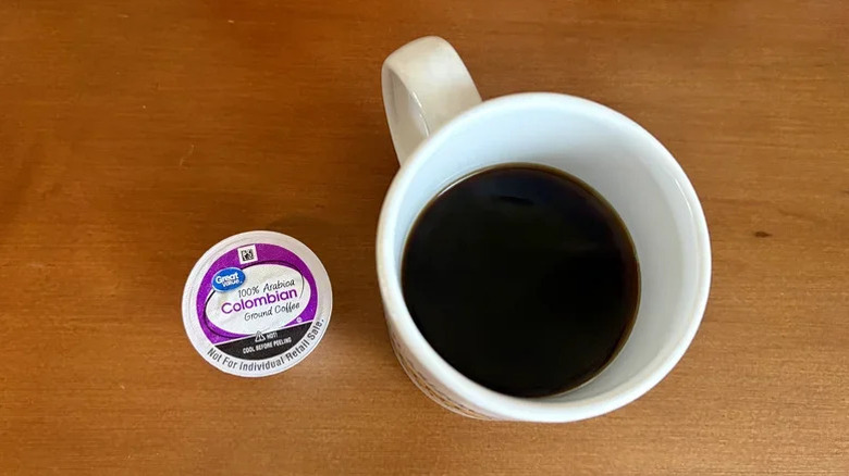 Great Value Colombian Medium Roast pod next to black coffee in a white mug