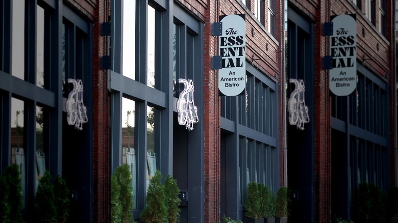 Exterior of The Essential with a sign on the wall