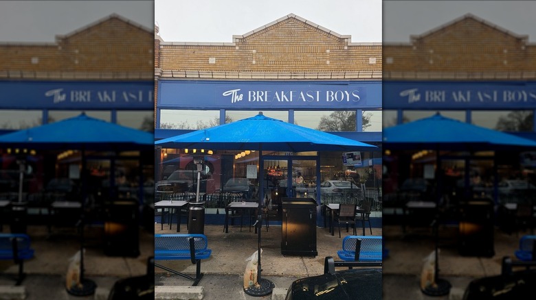 Exterior of The Breakfast Boys, including the patio with blue umbrellas