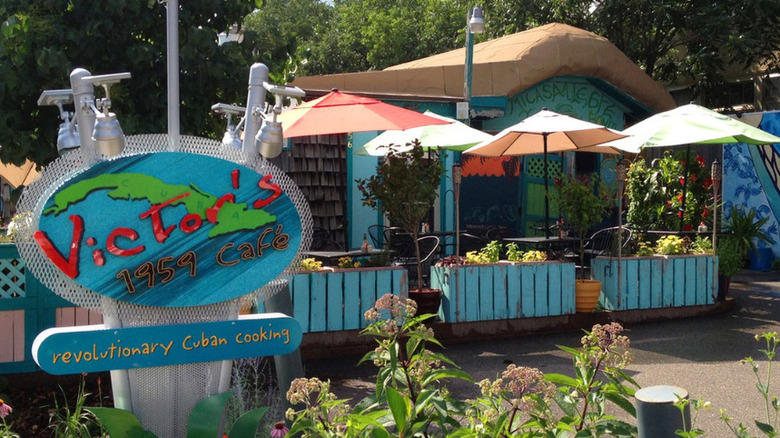 The painted blue exterior of Victor's 1959 Cafe with booths and umbrellas outside