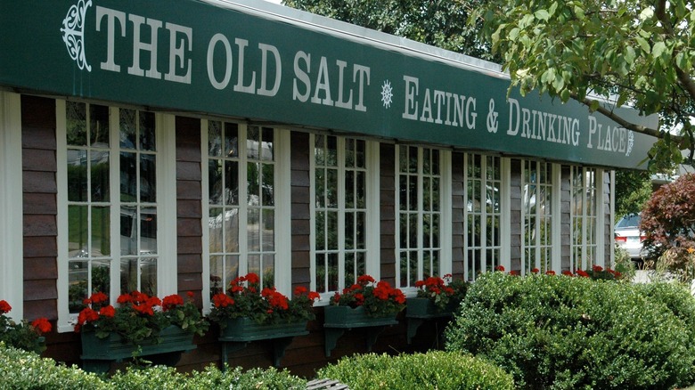 The exterior of The Old Salt with a green awning above the windows