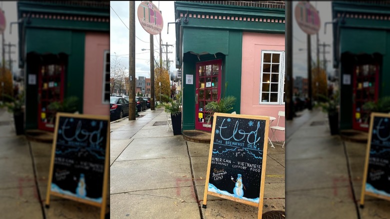 The pink and green exterior of The Breakfast Den with a chalkboard sign outside
