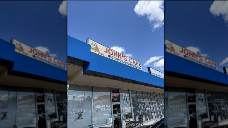 Exterior of John's Cafe with a cloudy blue sky in the background