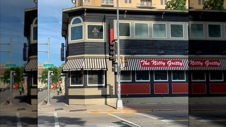 Exterior of Nitty Gritty with a striped white and black awning and a red sign