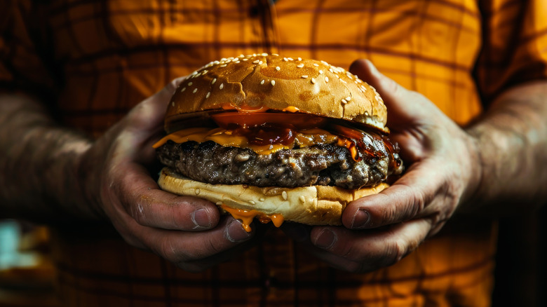 A man holding a cheeseburger