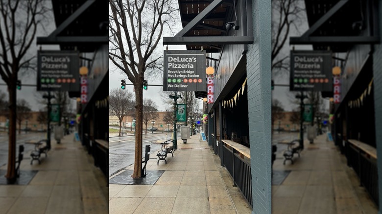 Exterior of DeLuca's Pizza, showing the sign and the street-facing counter