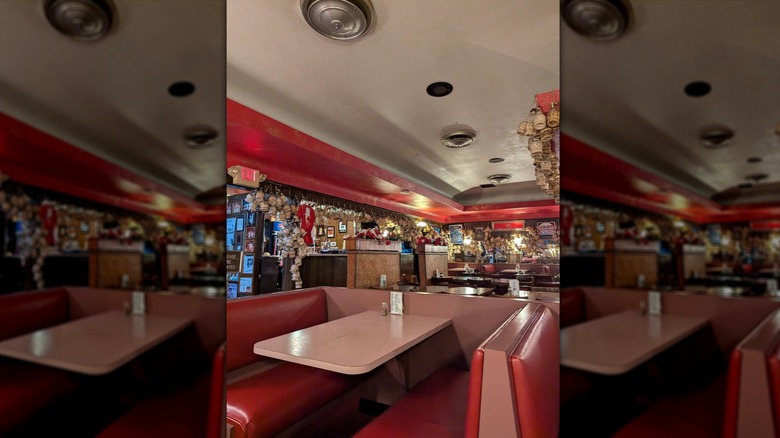 Dining area with a booth and red leather seats inside Loui's Pizza