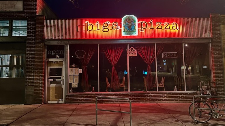The illuminated sign on the exterior of Biga Pizza at night