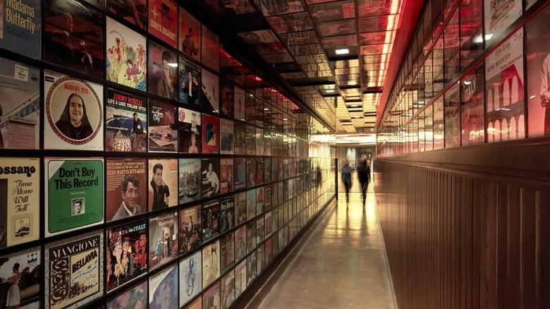 A hallway decorated with record cases leading to Secret Pizza