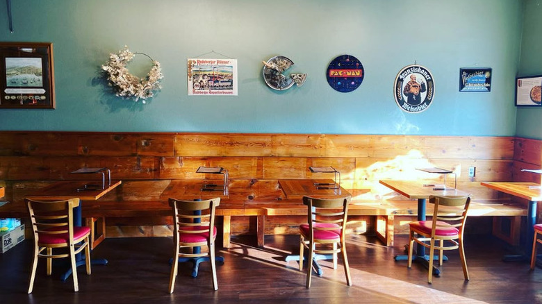 Dining area inside Apizza Scholls with wooden seating along the wall