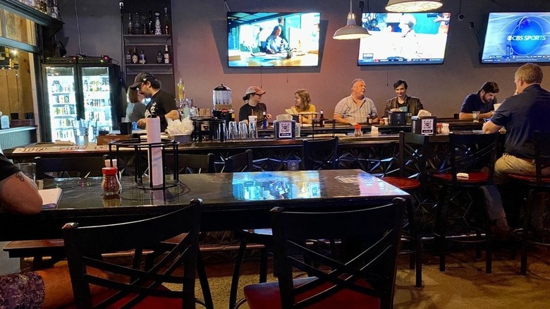 Bar and tables with people dining inside Midnight Oil