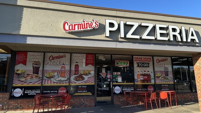 Exterior of Carmine's Pizzeria with tables outside in the shade