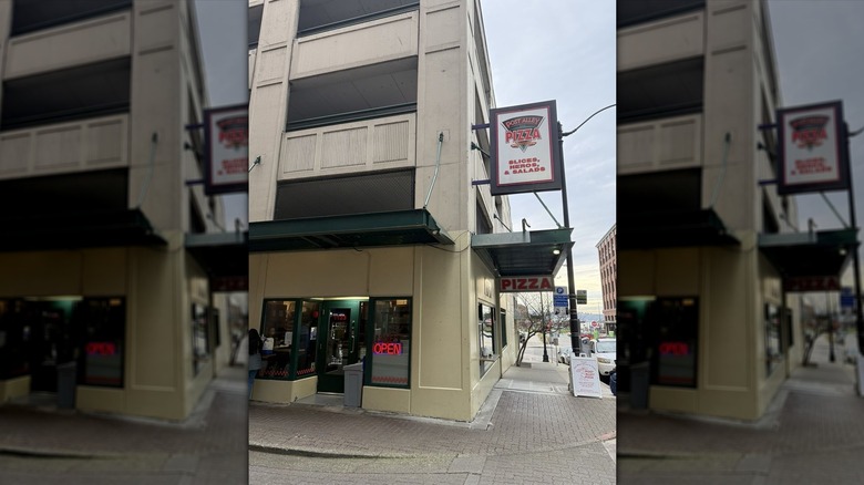 The exterior of Post Alley Pizza on a street corner in Seattle