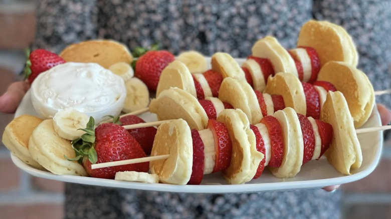 Pancakes and fruit on skewers in a plate