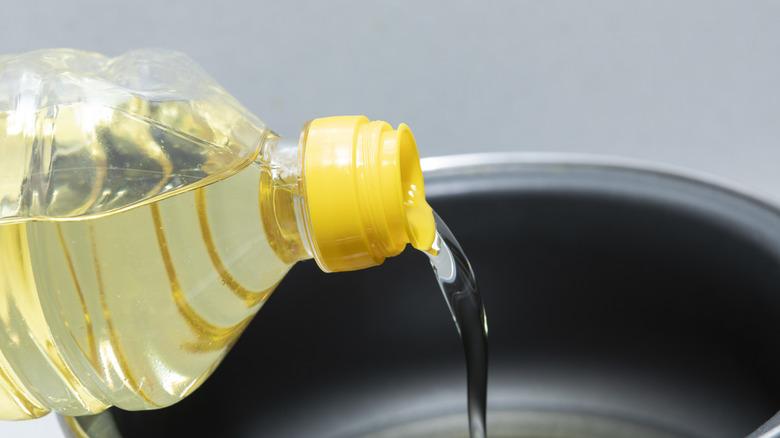 Pouring sunflower oil into pot